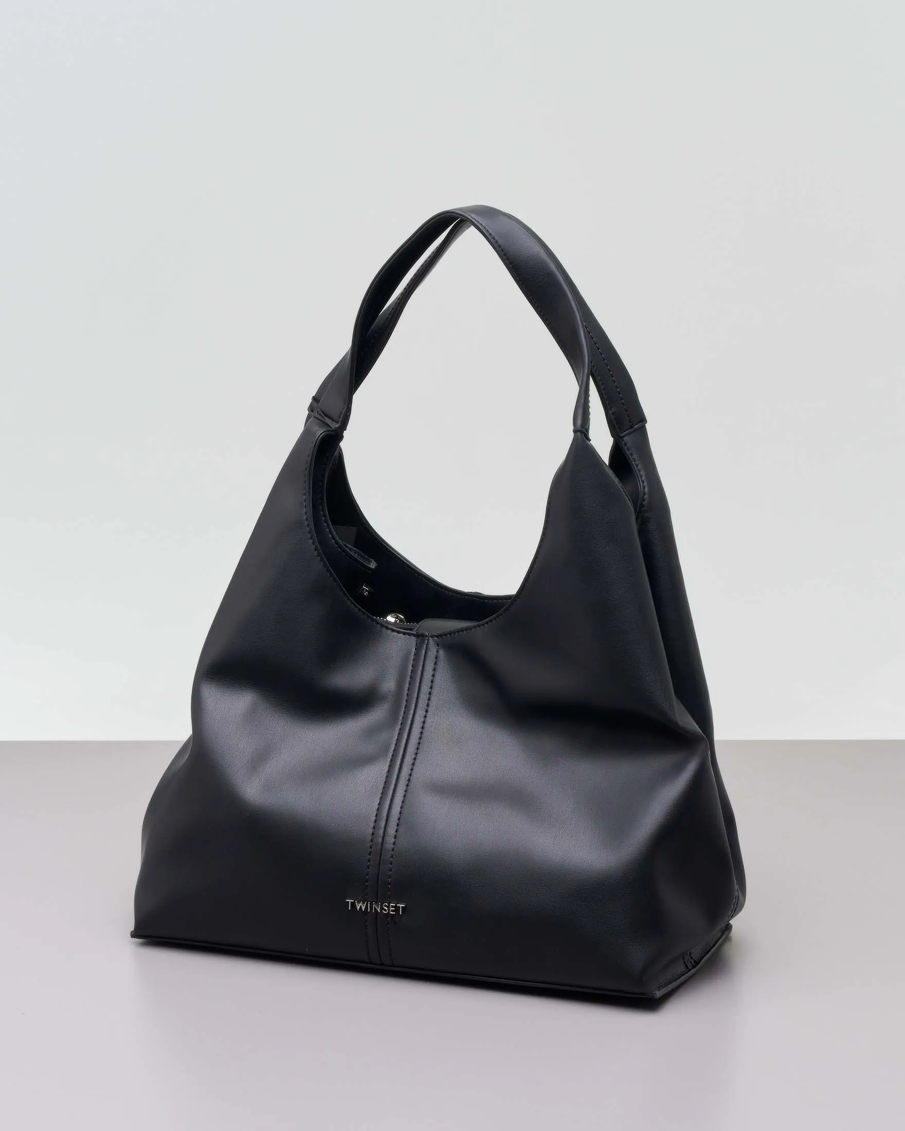 Black faux leather hobo bag with visible stitching and removable longer shoulder strap.